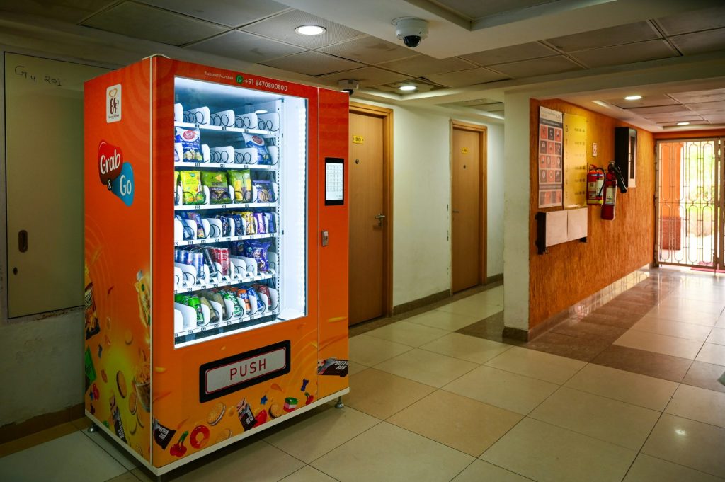 A vending machine sits inside a hallway.